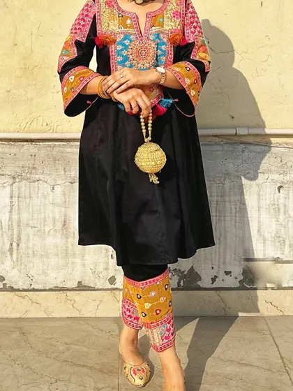A detail shot of the embroidered pants and golden potli, showing how accessories can echo the tones in your outfit.
