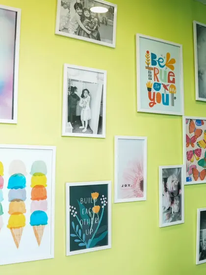 Our Wall of Joy! This wall is filled with colorful art and happy photos, reflecting the cheerful and welcoming vibe of our play cafe.