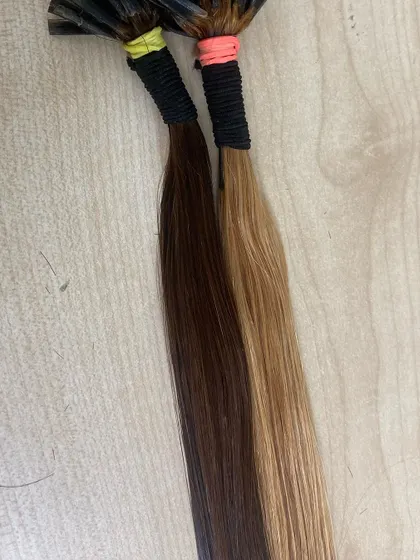 A comparison of two different shades of our I-Tip extensions, a dark brown and a lighter golden brown, showing our range of color options.