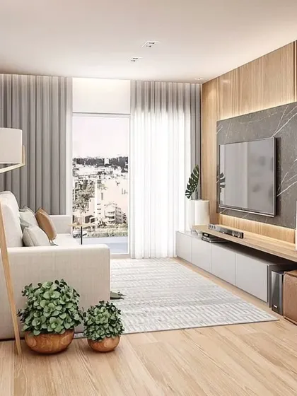 A compact and cozy living room with a light wood and marble TV unit, perfect for smaller apartments.