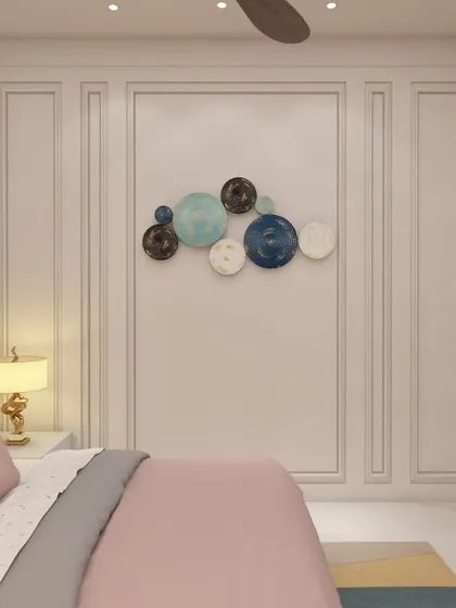 A close-up of the wall decor in a kid's bedroom, featuring decorative panel molding and a playful arrangement of circular art pieces. The design adds character and a touch of sophistication to the room.
