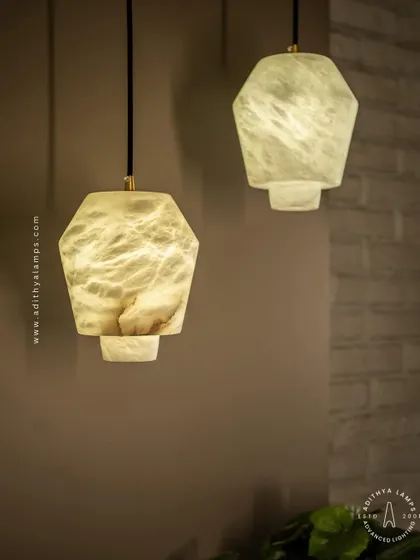 These geometric pendants are carved from a single piece of beige marble. Their unique, faceted shape and the soft glow from within make them a subtle yet elegant choice for modern kitchens or bedside lighting.