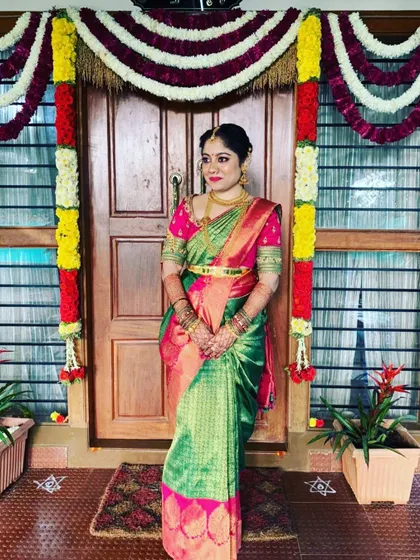 A full view of the bride's outfit, showcasing the custom-designed pink blouse with her traditional green silk saree. The fit and embroidery are tailored to create a seamless and beautiful look for her special day.