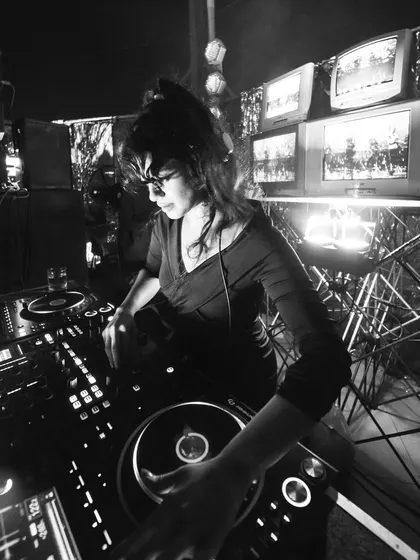 Focused on the mix. This black and white photo shows me in deep concentration, lining up the next track on the decks against a cool backdrop of retro TVs.