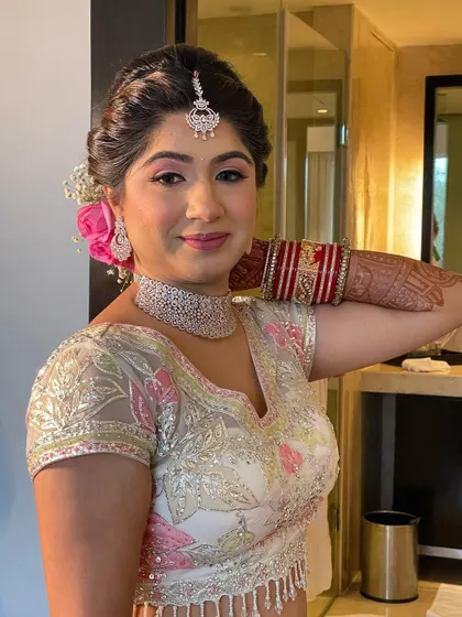The bride looks radiant and happy, her hairstyle perfectly complementing her look.
