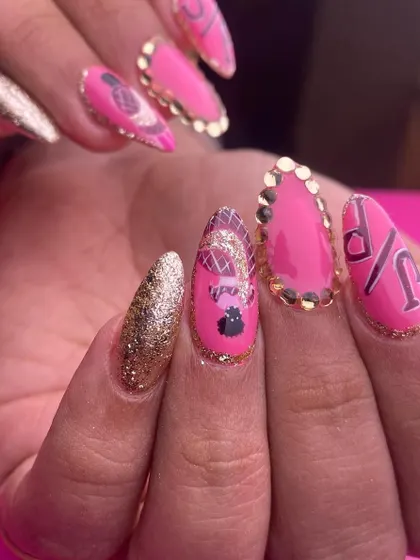 A bold and playful pink and gold set. This design features hot pink nails with gold glitter accents, gold-studded cuticles, and custom initial art for a personalized, glamorous look.