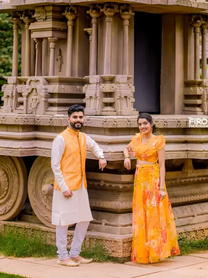 A classic pose by the stone chariot, with the couple in beautiful, bright traditional attire. This is a popular and timeless pre-wedding photo idea.