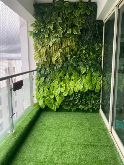 Even a narrow apartment balcony can become a green escape. Here, we installed durable artificial turf and a dense, artificial green wall to provide privacy and a vibrant backdrop without requiring any maintenance.