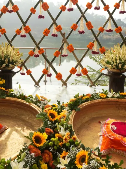 A closer look at the decorated brass urlis, ready for the Haldi ceremony, surrounded by a ring of sunflowers and other blooms.