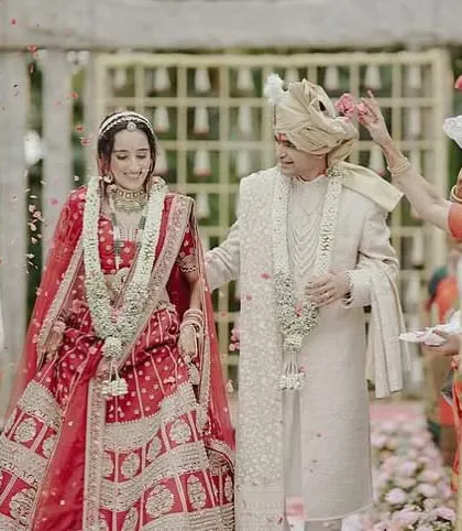 A candid moment from the wedding ceremony, with flower petals showering the happy couple. The bride's natural makeup looks fresh and beautiful throughout the event.