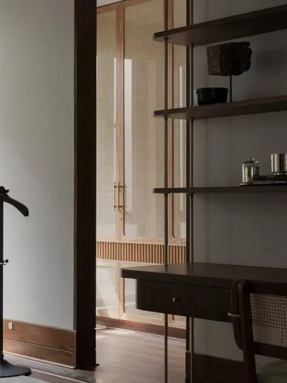 A detail shot from the Pràna house, showing a custom desk and shelving unit. The cane-fronted doors in the background add a layer of texture and warmth.
