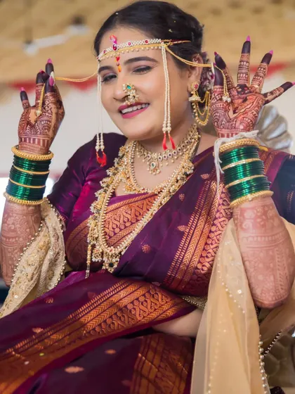 A playful and happy bride shows off her henna-covered hands with a wink, capturing her fun-loving personality.