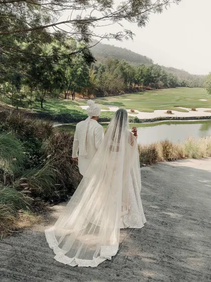 A portrait from behind, showcasing the magnificent veil and the stunning landscape. This image tells a story of a journey beginning, with the couple walking towards a beautiful, open future.
