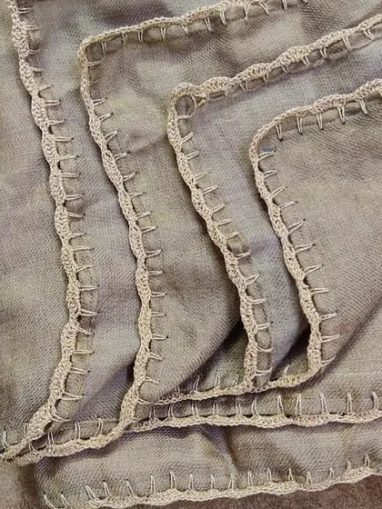 For a unique look, we added a simple yet elegant crochet lace edge to this beautiful grey shawl. This kind of custom work can completely transform a piece.