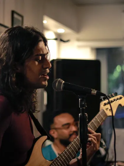 A guitarist lost in the music during a live session. The close-up shot captures the intensity and focus of a performer in their element.
