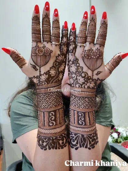 A close up of this beautiful back of hand design with hanging lotus motifs. The red nails make the henna pop!