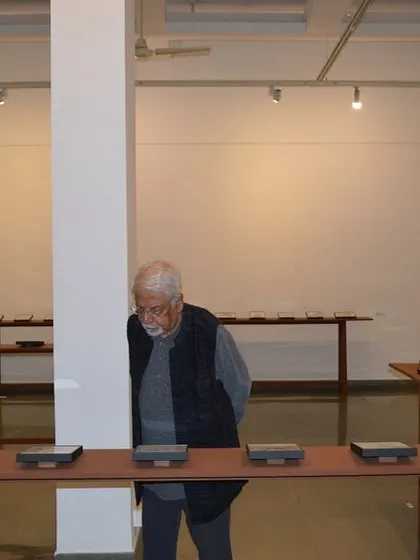 An art patron observing the reverse paintings on display at 'Quieter than Silence'.