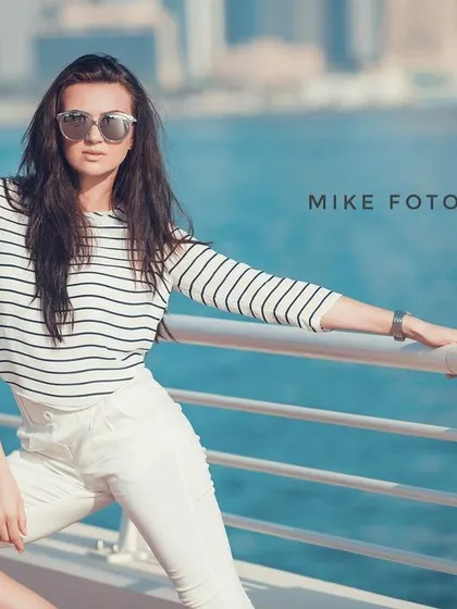 A confident portrait on the Dubai waterfront. The direct gaze of the model and the clean, bright background make this a strong and compelling shot for a personal branding portfolio.