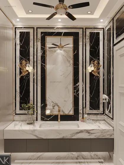 A close-up of the vanity in the neoclassical washroom. The design uses dramatic black marble panels with white veining, framed with elegant moulding and accented by cherub-themed wall sconces.