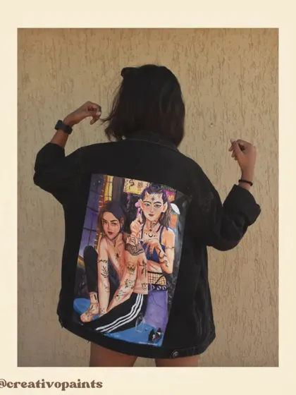 A posed shot that highlights the composition of the two figures painted on the back of the jacket, showcasing the narrative within the artwork.