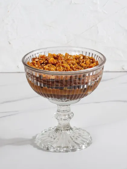 Our Chocolate & Salted Caramel Trifle in a glass goblet, showing the rich chocolate layers topped with a crunchy, nutty crumble.