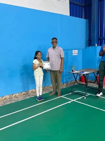 A young player receives her certificate and a small trophy at our academy's prize distribution ceremony, marking her successful participation.
