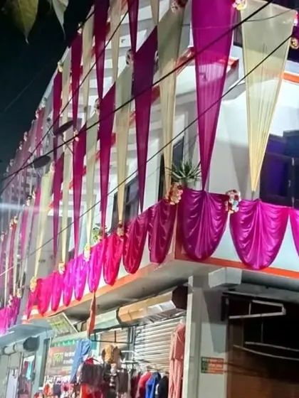 A house facade at night decorated with vertical drapes in off-white and pink, creating an elegant and festive look.