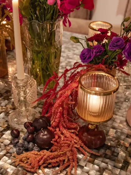 A similar detail shot, showing the rich colors of the fruits and flowers against the unique mother-of-pearl tabletop. The combination of textures is a feast for the eyes.