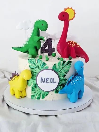 A cute dinosaur-themed cake for Neil's fourth birthday, with four colorful, hand-sculpted dinosaurs.