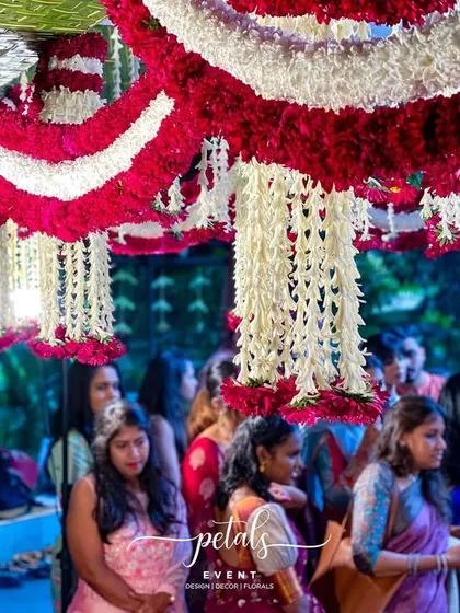 A candid shot of the guests during the wedding ceremony, framed by the beautiful floral decor. The atmosphere is one of joy, reverence, and celebration.