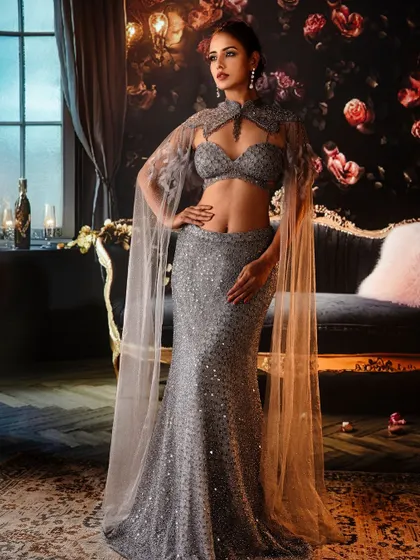 Elegance personified in shimmering silver. The projected backdrop of a luxurious, moody room adds a layer of glamour and sophistication, making the sequined gown sparkle.