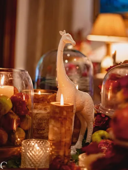 Another look at the charming giraffe figurine, nestled amongst the candles and fruit. These small, curated objects help to tell the story of the event.