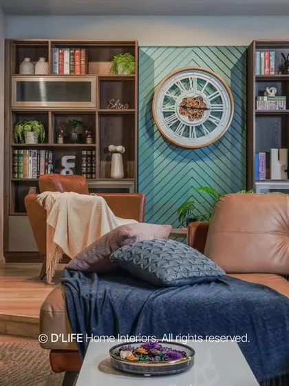 A comfortable and stylish living room with a large leather sectional, custom built-in bookshelves, and a large wall clock as a decorative feature.