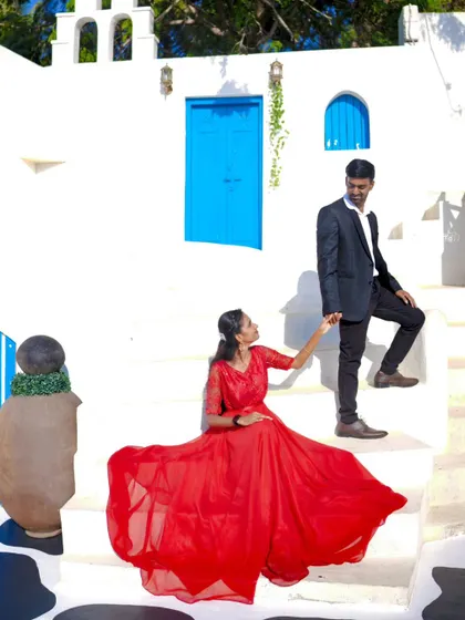 A creative pose on the stairs of a picturesque set. The flowing red gown adds a beautiful pop of color.