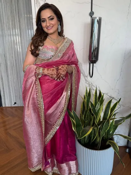 A full-length view of the client in her beautiful pink saree, with her hair in soft, glamorous waves.