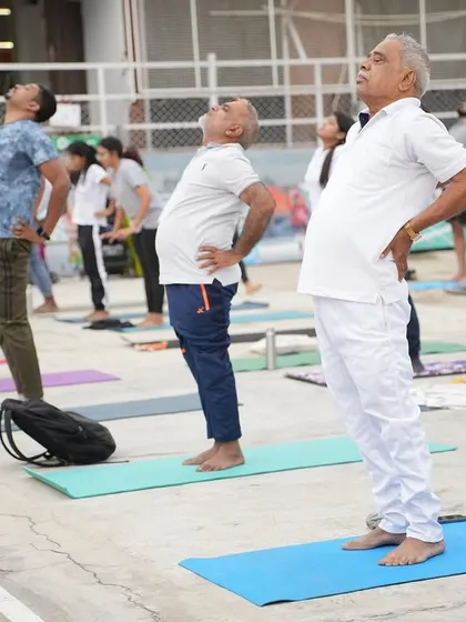 Participants of all ages in a standing backbend during our International Yoga Day event.