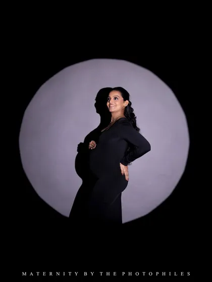A dramatic spotlight portrait that creates a sense of being on stage. This technique highlights the mom-to-be's confidence and glow.