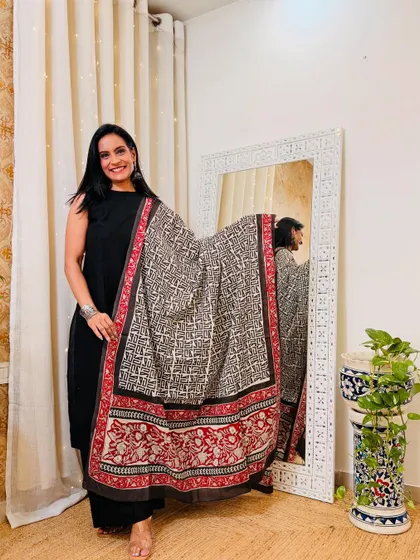 A solid black kurta and pant set paired with a beautiful hand-block printed dupatta. This is a classic, versatile outfit that you can style in many ways.
