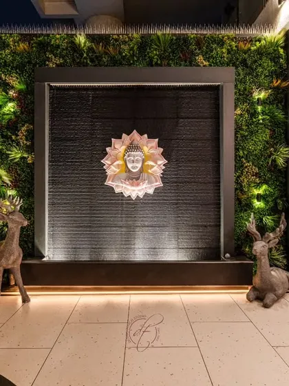 The focal point of the terrace is this serene Buddha water feature, framed by a lush green wall. The gentle sound of water and the soft lighting make it a perfect spot for meditation and relaxation.