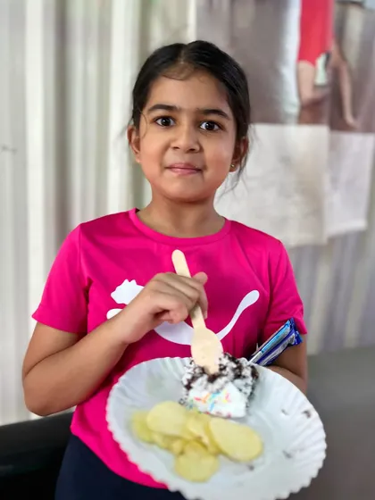 Cake and chips, the perfect party combination. This student enjoys her plate of treats during a studio celebration.