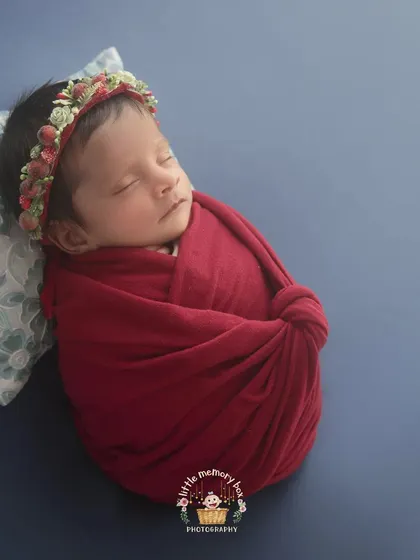 The rich red wrap against a deep blue background creates such a striking and beautiful contrast. I love using bold colors to create powerful and memorable newborn portraits.