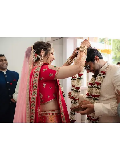A playful moment during the varmala ceremony, showcasing the fun and lighthearted side of wedding rituals.