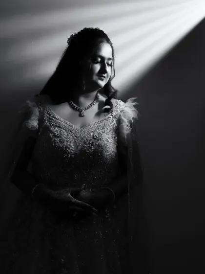 A stunning black and white bridal portrait using a single beam of light. This dramatic lighting technique creates a timeless and artistic image that highlights the bride's features.