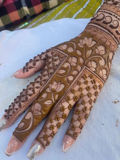 A stunning back-of-hand design featuring a beautiful lotus vine pattern. The intricate net pattern on the fingers adds to the overall elegance.