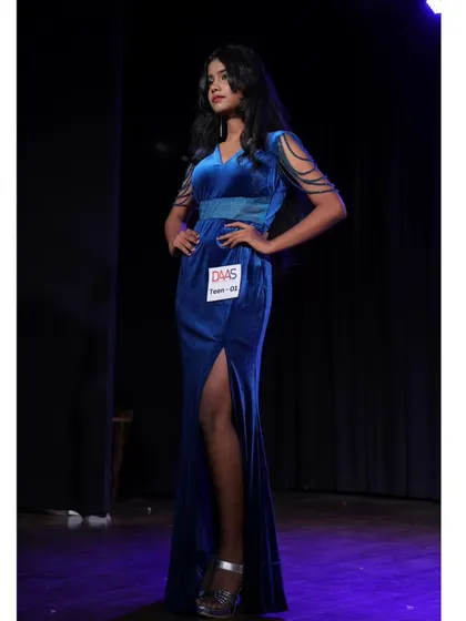 Another pose from the stage event, showing the full length of the blue velvet gown.