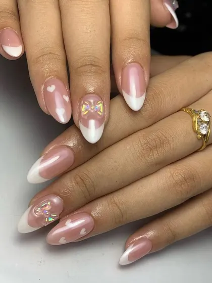 For the romantic at heart. A classic French manicure gets a sweet update with translucent hearts and a delicate 3D bow charm.
