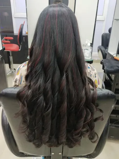 I love creating these big, glamorous curls after a color service. They perfectly showcase the subtle red highlights woven into the dark hair.