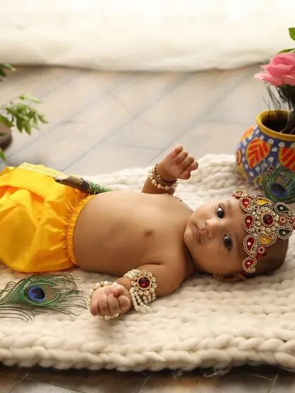 Even the tiniest babies can join the celebration. This newborn, dressed as Krishna, looks so peaceful amongst the flowers.