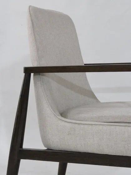 A close-up of the arm and seat, showcasing the beautiful grain of the wood and the texture of the fabric.