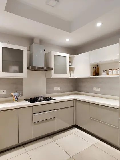 A beautiful two-tone kitchen featuring beige lower cabinets and white upper cabinets. The frosted glass doors on the upper units add a touch of lightness, while the open shelving provides space for display.